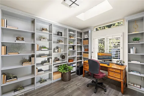 a view of a workspace with furniture and a window
