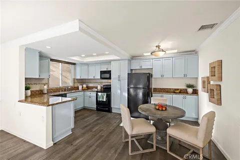 a kitchen with refrigerator a sink and chairs