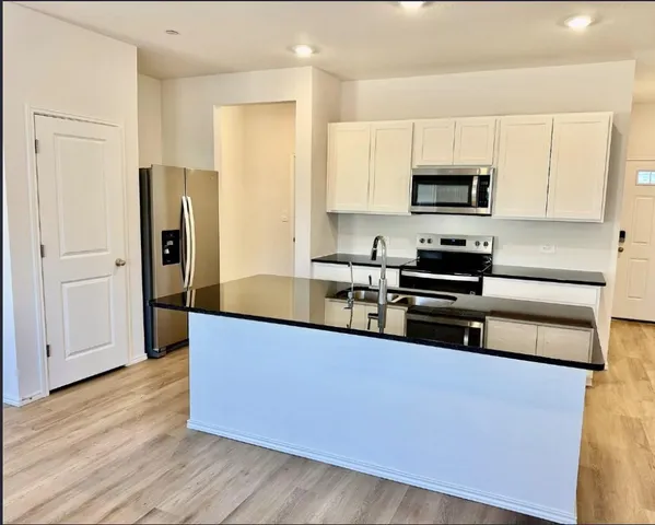 a kitchen with stainless steel appliances a refrigerator sink and cabinets