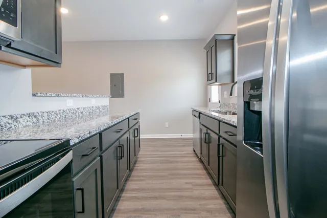 a kitchen with granite countertop a sink and stove