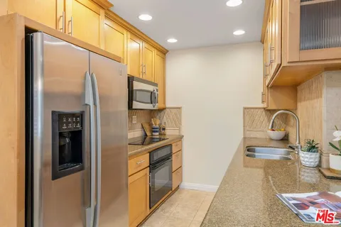 a kitchen with stainless steel appliances granite countertop a refrigerator and a stove