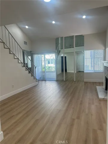 a view of a livingroom with wooden floor and staircase