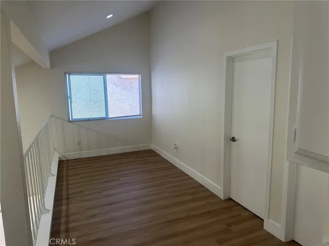 an empty room with a window and ceiling fan