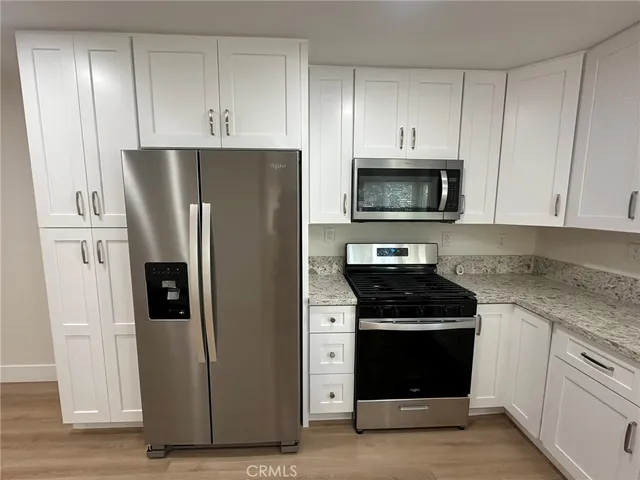 a kitchen with refrigerator a microwave and cabinets