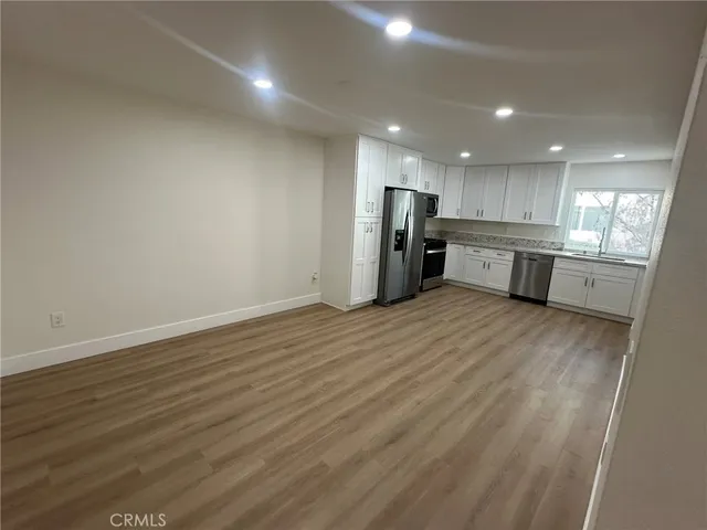 a large kitchen with a lot of cabinets and wooden floor