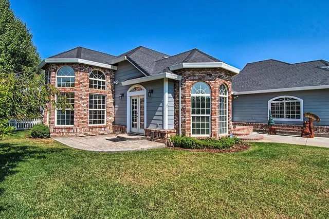 a kitchen with stainless steel appliances granite countertop a stove top oven a sink a dining table and chairs