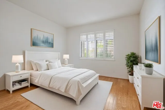 a bedroom with a bed and a potted plant