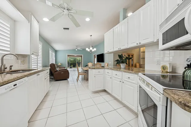 a kitchen with granite countertop a sink a counter top space appliances and cabinets