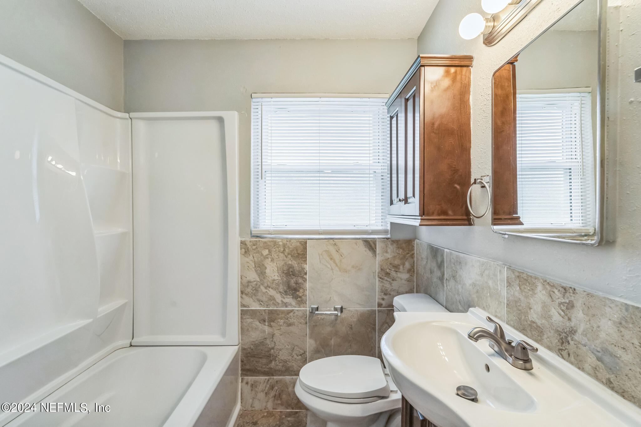 6974 Rollo Road Jacksonville, FL 32205 - Photo 9 of 16 a bathroom with a sink a toilet and tub