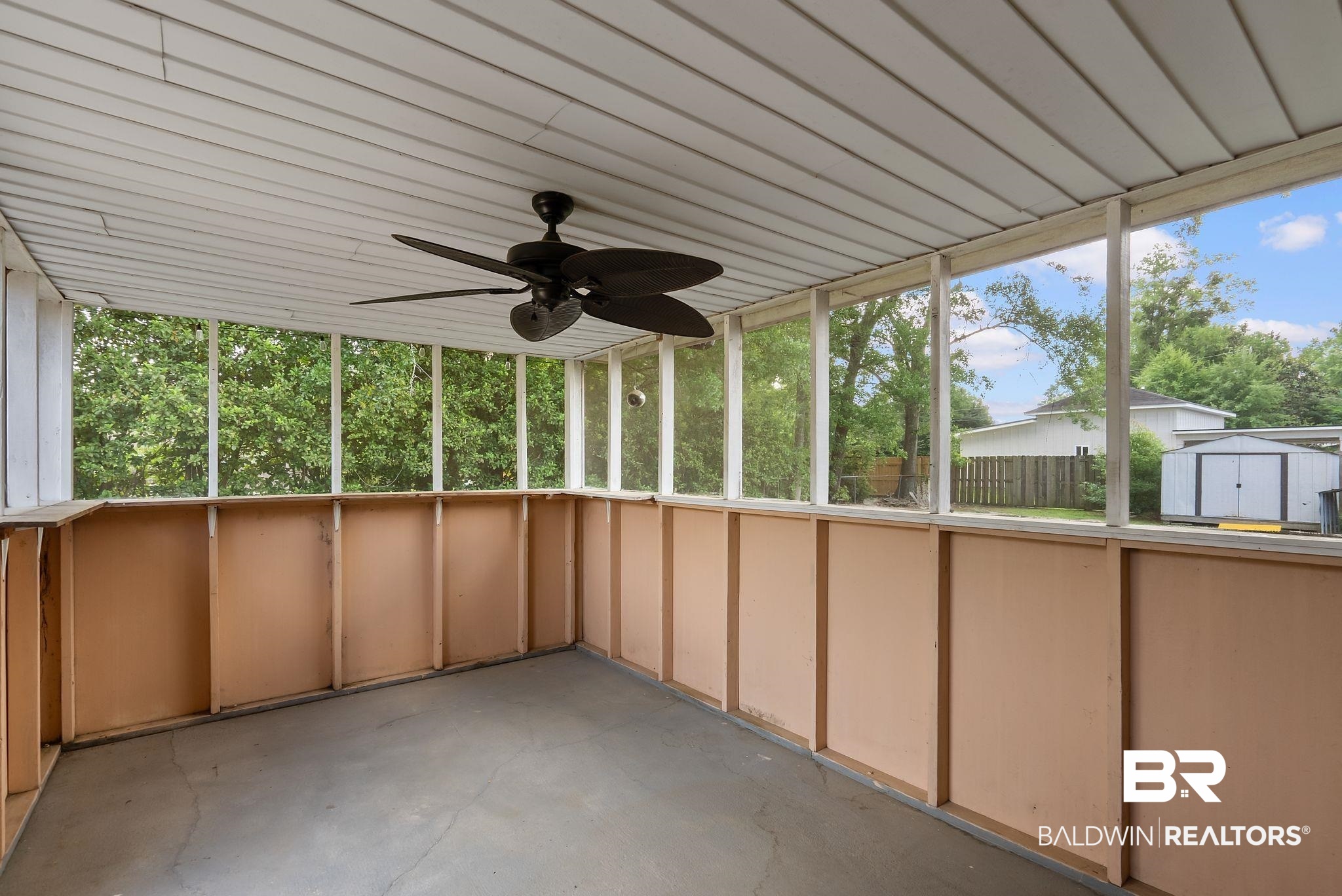 716 North Cedar Street Foley, AL 36535 - Photo 20 of 25 Screened porch with concrete flooring and a ceiling fan