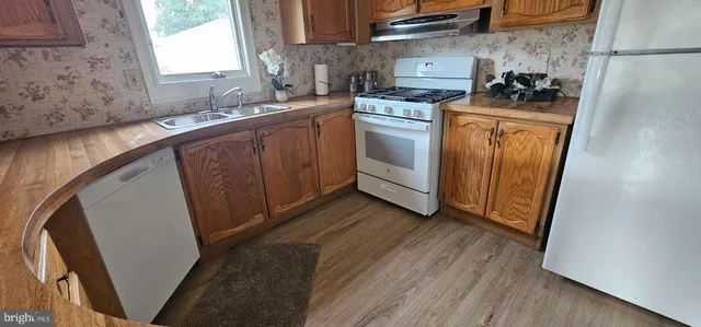 a kitchen with granite countertop a sink a stove a washer and dryer