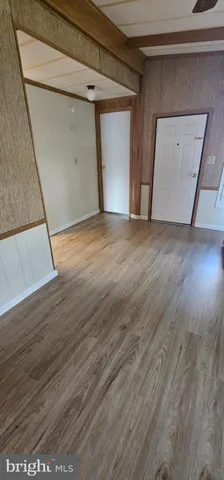 a view of empty room with wooden floor