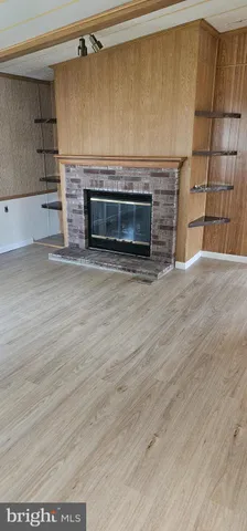 a view of an empty room with a fireplace and a window