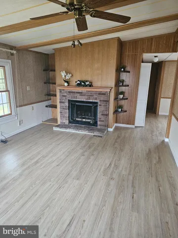 wooden floor fireplace and windows in an empty room