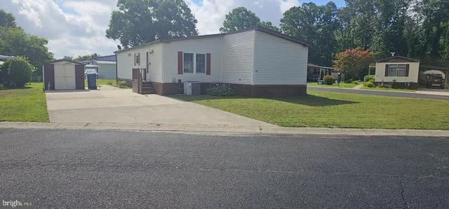 a front view of a house with a yard and trees