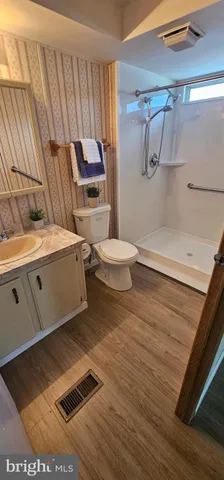 a bathroom with a sink a toilet and shower