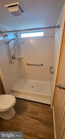 a bathroom with a toilet and a shower