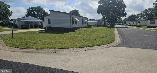a view of a white house with a swimming pool and a yard