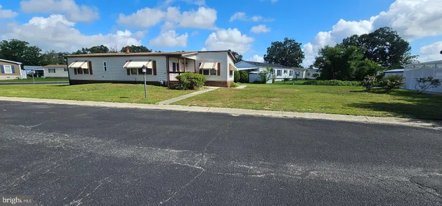 a view of a house with a big yard and large trees