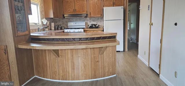 a kitchen with kitchen island a counter top space a sink and a refrigerator