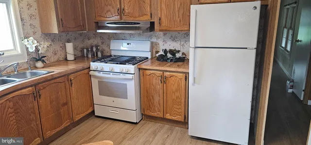 a kitchen with a refrigerator sink and cabinets