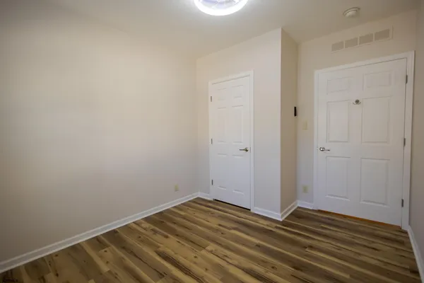 a view of a room with wooden floor and white doors