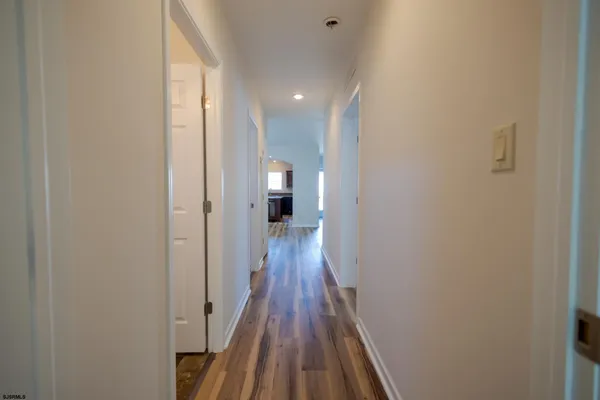 a view of a hallway with wooden floor