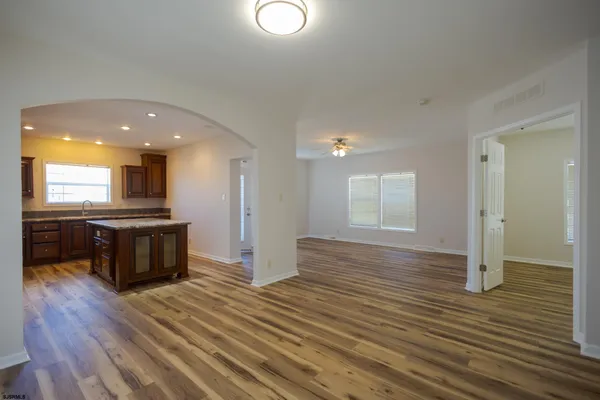 an empty room with wooden floor and entrance
