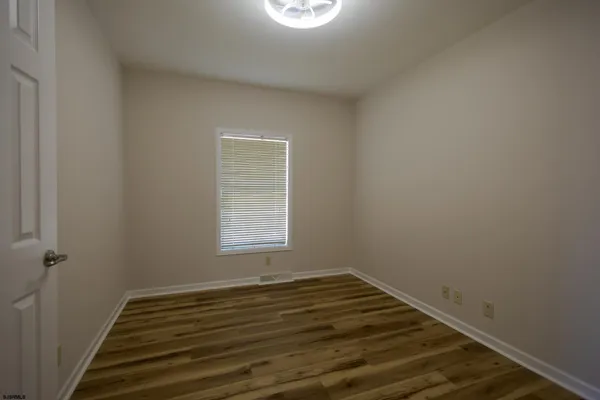 a view of a room with wooden floor and window
