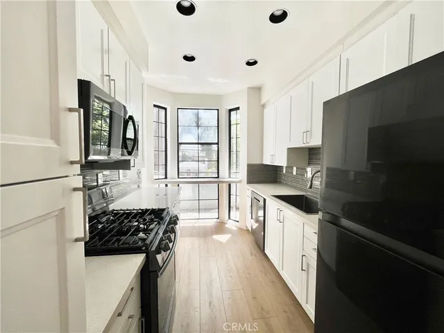 a kitchen with a sink a stove and cabinets