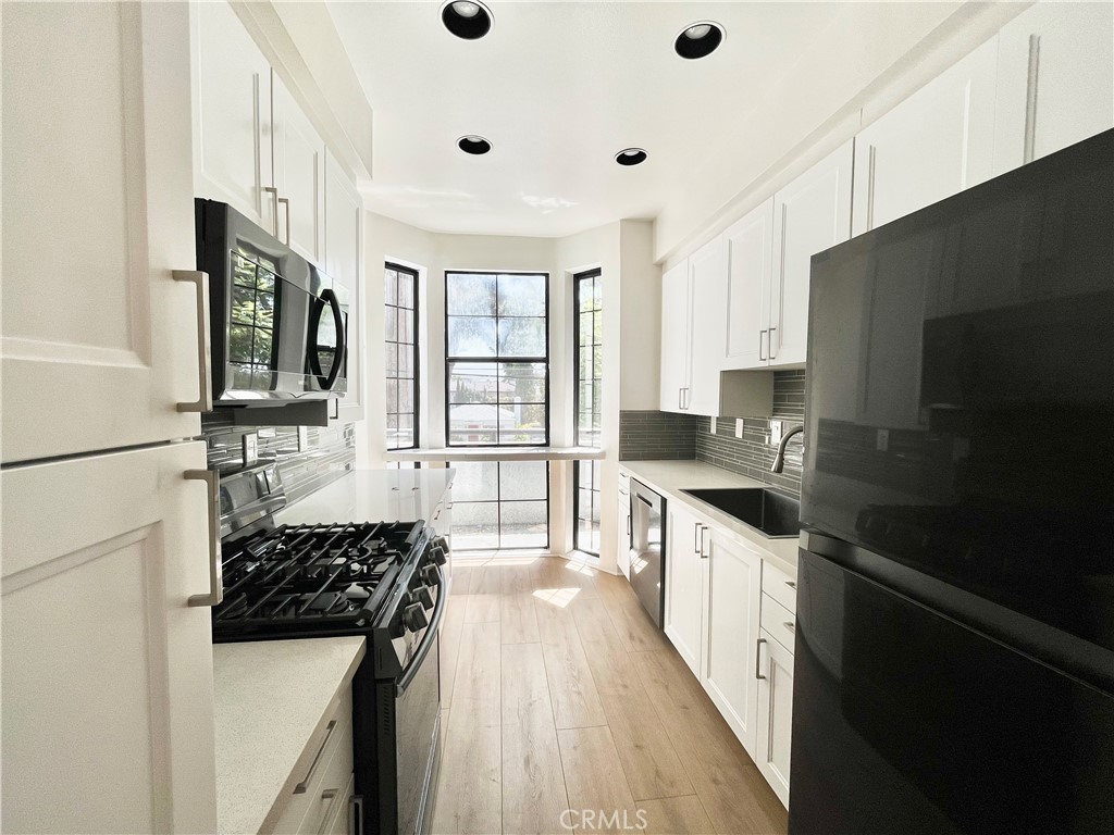 a kitchen with a sink a stove and cabinets