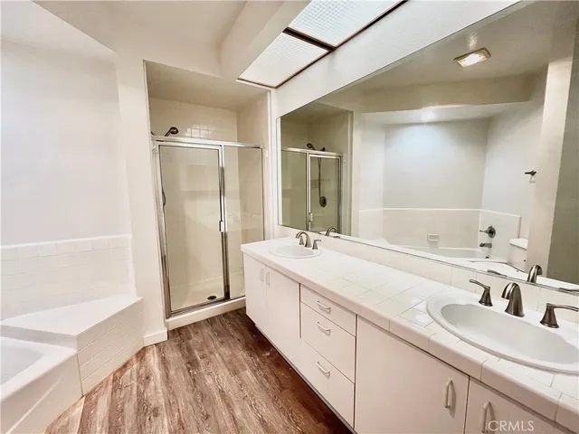 an empty room with wooden floor and windows with curtains