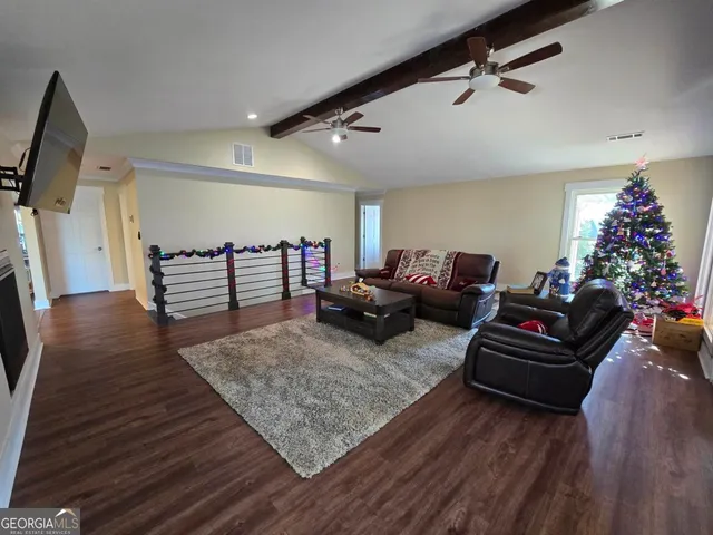 a living room with furniture and wooden floor