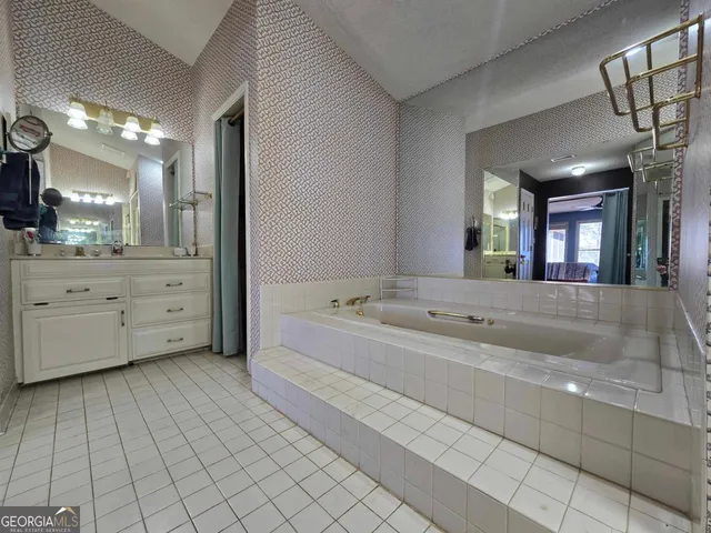 a bathroom with a bathtub a mirror a double vanity sink and vanity