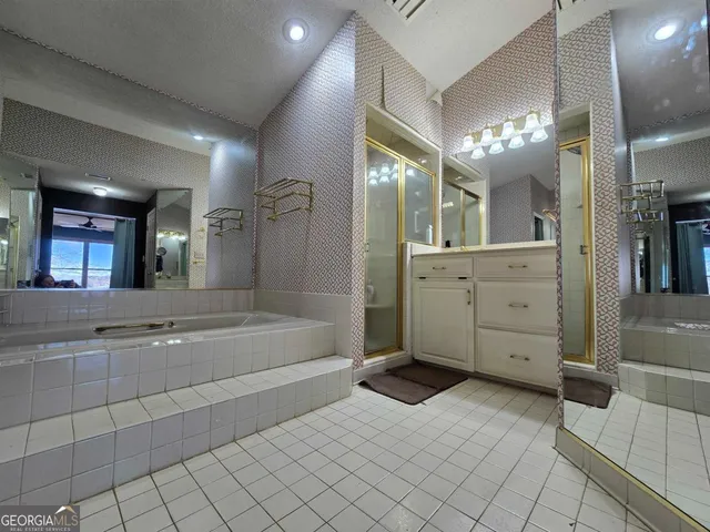 a spacious bathroom with a mirror sink and bathtub