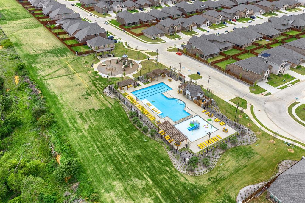 3808 High Country Road Aubrey, TX 76227 - Photo 35 of 36 Community recreation area featuring two swimming pools, a playground, and shaded lounge areas