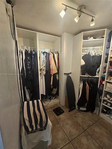 a view of walk in closet with clothes