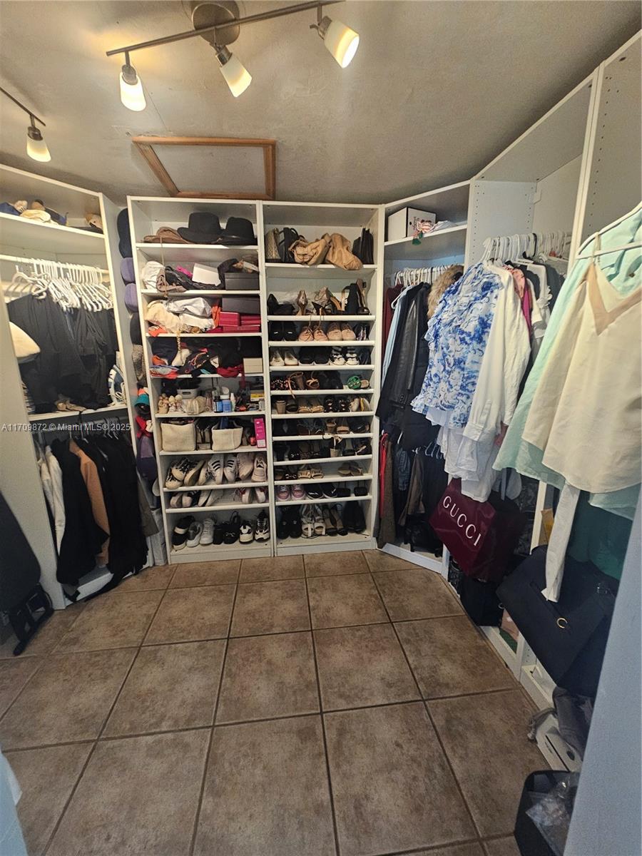 14461 Southwest 152nd Court Miami, FL 33196 - Photo 17 of 30 a view of walk in closet with clothes and shoes