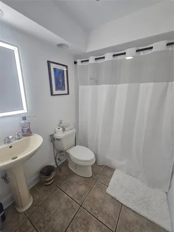 a bathroom with a toilet sink and shower