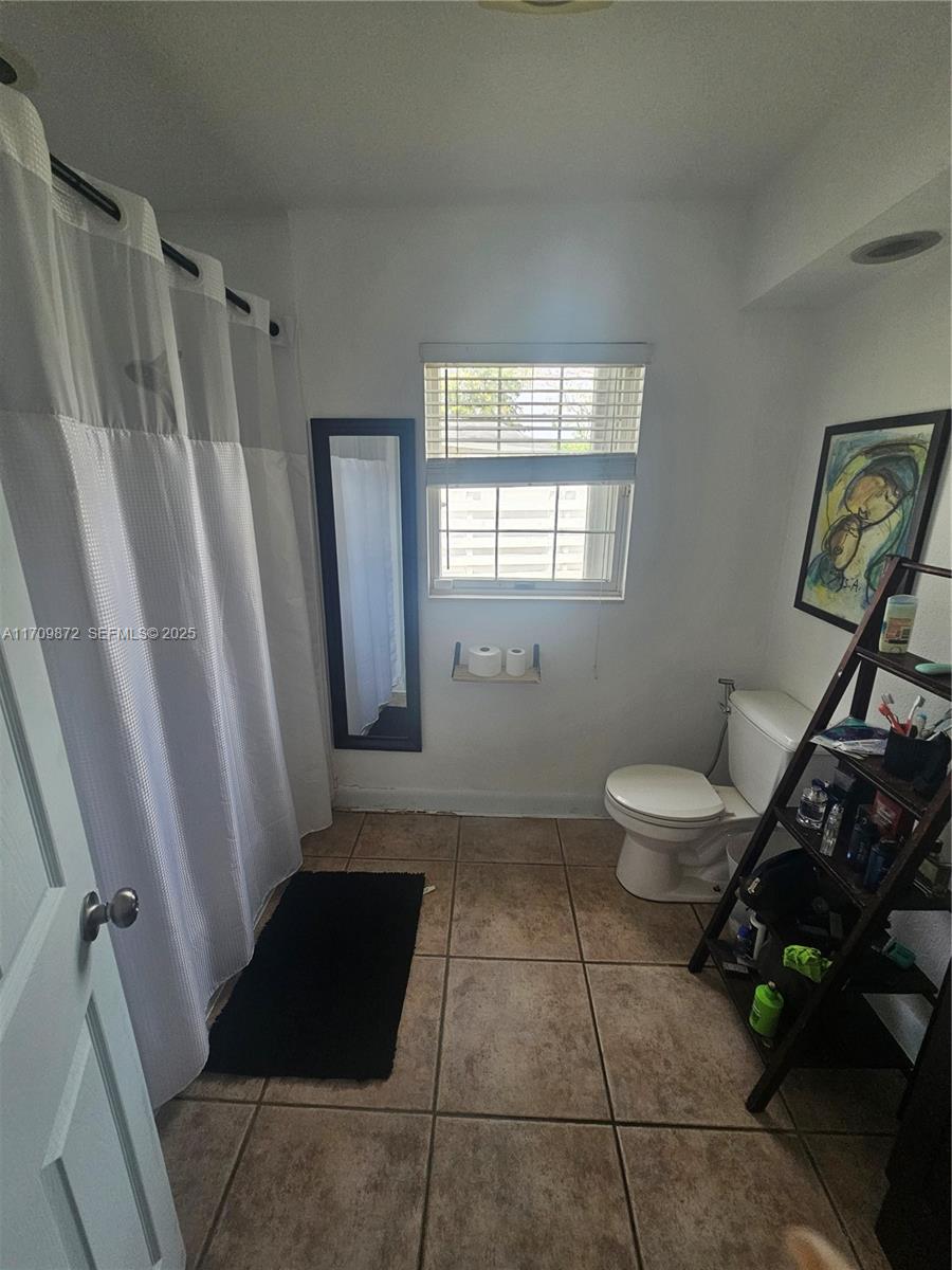 14461 Southwest 152nd Court Miami, FL 33196 - Photo 23 of 30 a bathroom with a toilet a window and a shower