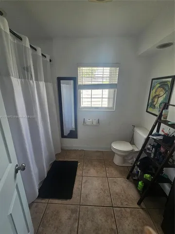 a bathroom with a toilet a window and a shower