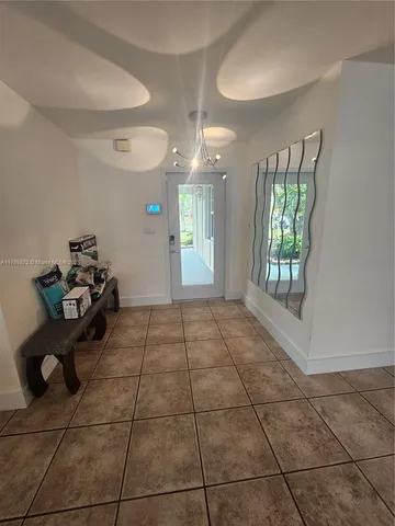 a room with a black white checkered floor and a chandelier