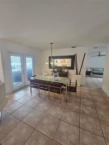 a living room with furniture a dining table and a large window