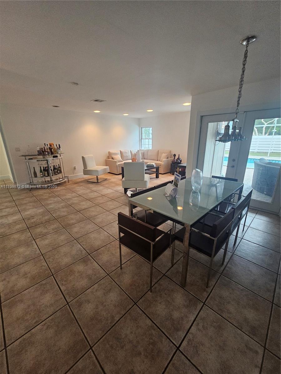 14461 Southwest 152nd Court Miami, FL 33196 - Photo 10 of 30 a living room with couches and kitchen view with wooden floor