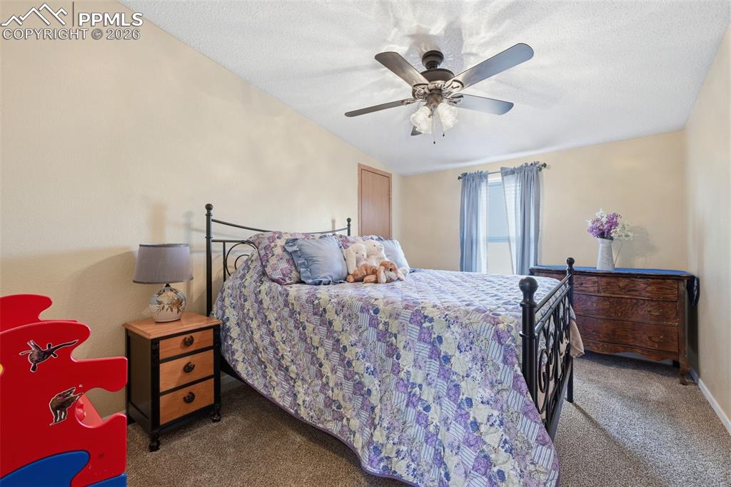 20985 McDaniels Road Calhan, CO 80808 - Photo 35 of 41 a bedroom with a bed and a chandelier
