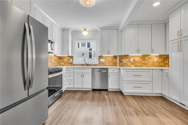 a kitchen with white cabinets and white appliances