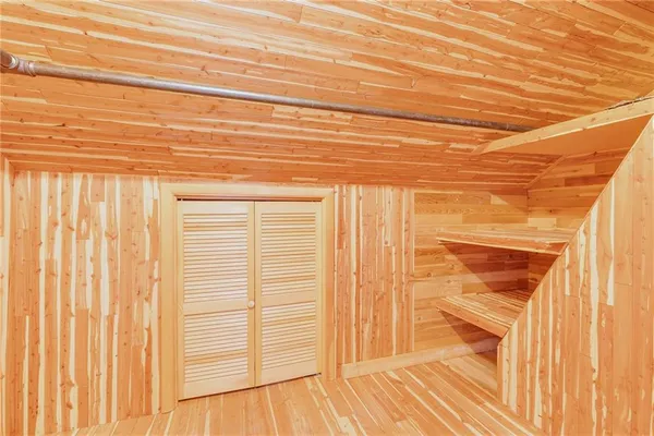 a view of a closet area with wooden floor