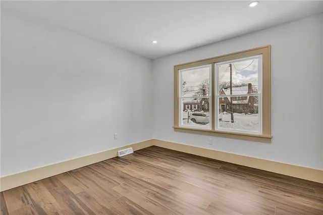 wooden floor in an empty room with a window
