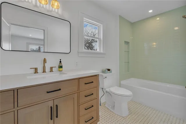 a spacious bathroom with a granite countertop sink a toilet a mirror and vanity