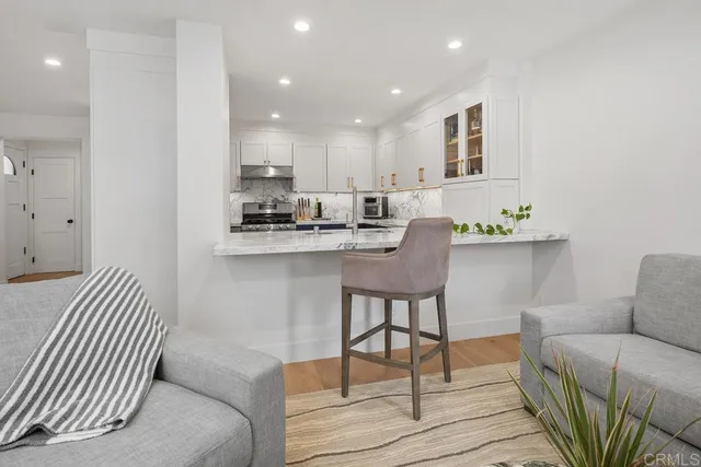 a living room with furniture a large window and wooden floor